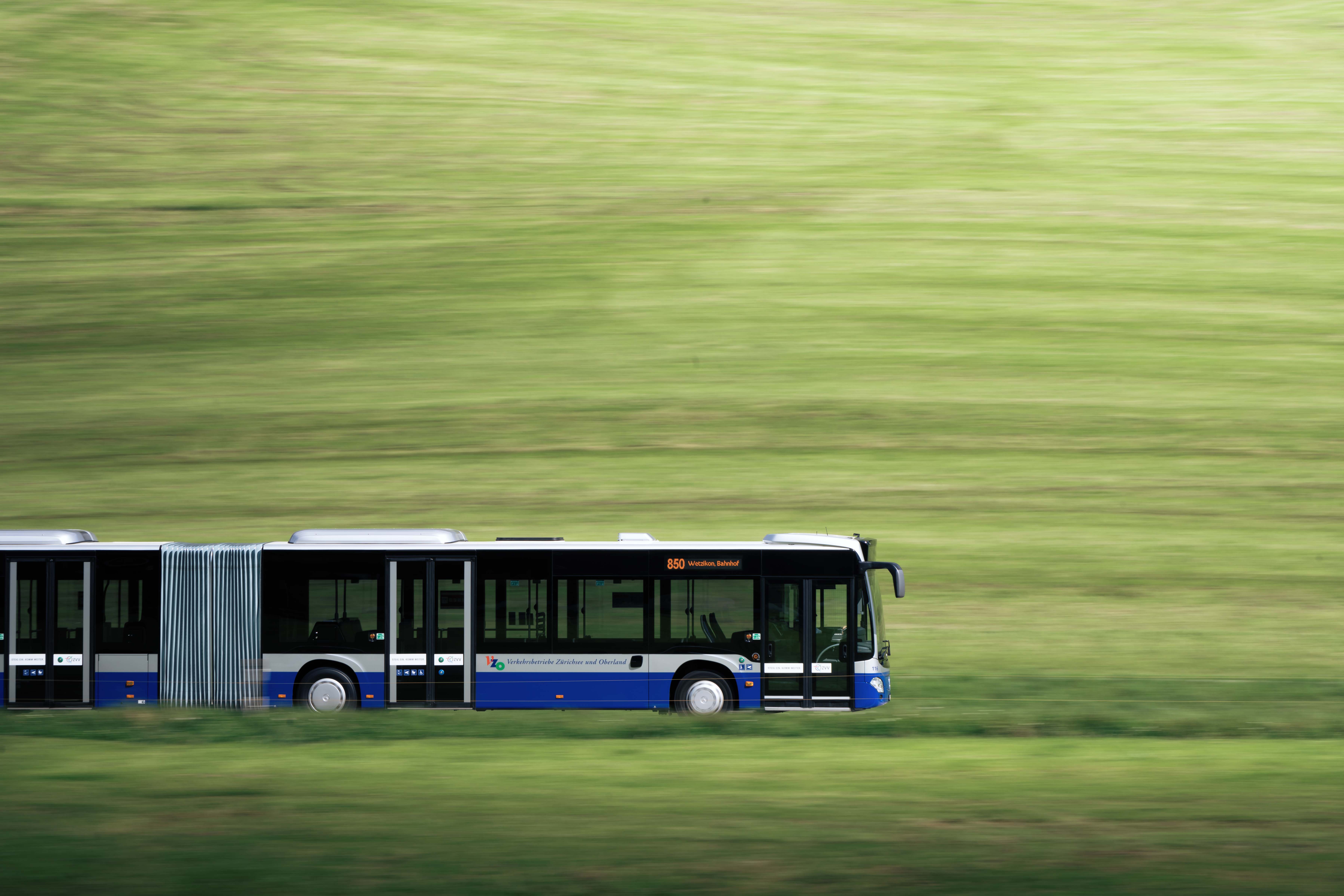 Ein Bus der VZO mit Sitz in Grüningen fährt durch die grüne Landschaft. Ein Bus der VZO mit Sitz in Grüningen fährt durch die grüne Landschaft.